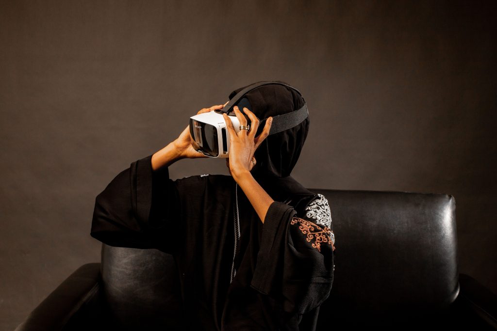 Woman in traditional clothing wearing a VR headset, exploring new virtual worlds.